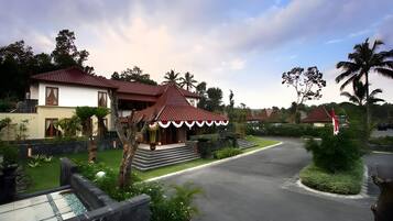 A residential area with two houses, a paved driveway, and a well-maintained garden.
