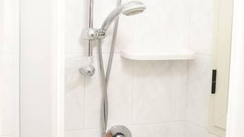 Une douche équipée d’un pommeau de douche à main et d’un pommeau de douche fixe fixé au mur.