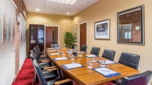A conference room with a long table, black chairs, and framed pictures on the walls. - Parkway Hotel and Spa (Cwmbran)