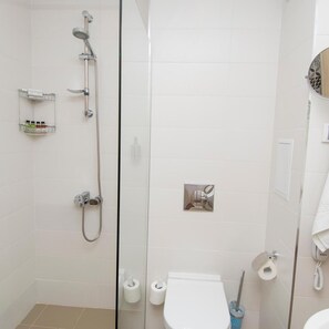 A modern bathroom with a glass shower enclosure, a toilet, a bidet, and a hand dryer. - Nevis Resort & Aqua Park - All Inclusive (Nessebar)