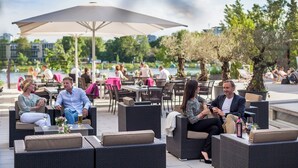 A patio area with outdoor seating, tables, and umbrellas. - Hotel 47 (Konstanz)
