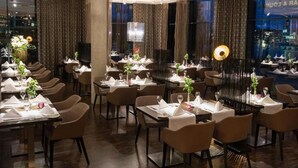 A restaurant with multiple tables set for dining, featuring a modern interior with dark wood flooring and ambient lighting. - Hotel 47 (Konstanz)