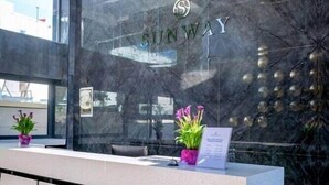 A reception desk with a marble wall and a clear glass window. - Sunway Hotel (Kassandra)