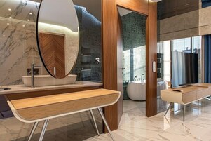 Un baño moderno con tocador de madera, un espejo grande y piso de baldosas de mármol.