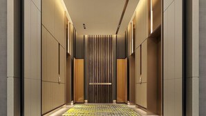A modern elevator interior with a geometric patterned floor, vertical wooden slats, and recessed lighting. - Genpla Hotel Shenzhen Nanshan (Shenzhen)