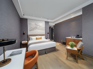 A modern hotel room with a bed, desk, chair, and a small dining area. - Genpla Hotel Shenzhen Nanshan (Shenzhen)