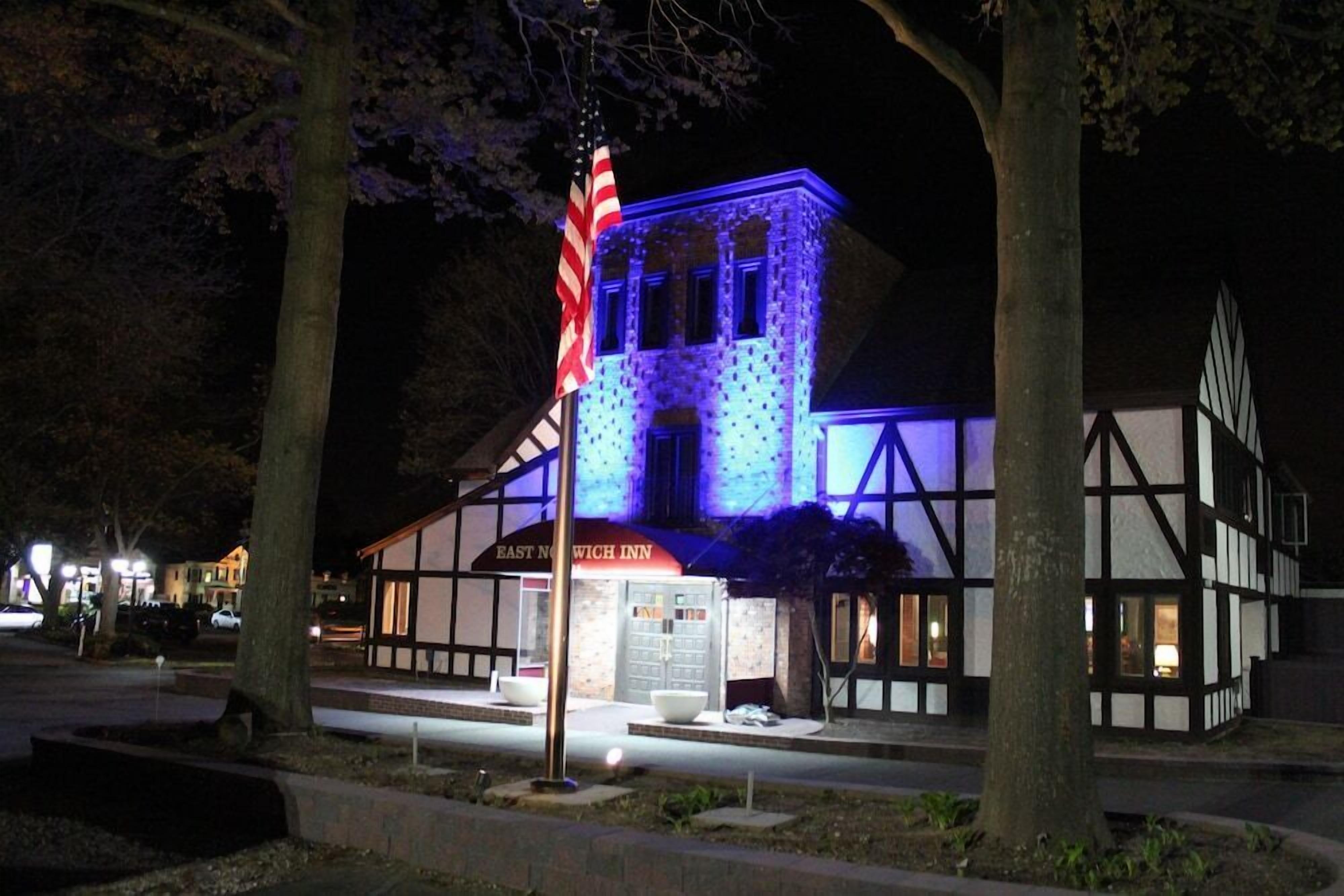 A traditional building with a sign reading "EAST NICHOLAS INN" at night, illuminated by blue lighting.