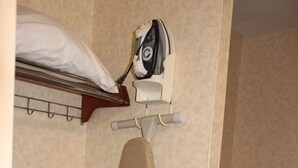 Ein Teil eines Hotelzimmers mit Bügelbrett, Bügeleisen und einem Handtuchhalter.