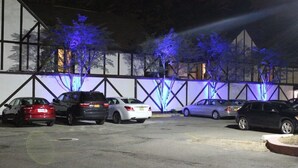 Ein Parkplatz mit mehreren Autos vor einem Gebäude mit einer geometrischen Fassade.