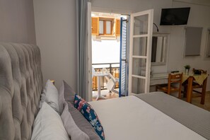 Een hotelkamer met een bed, een bureau en een televisie.