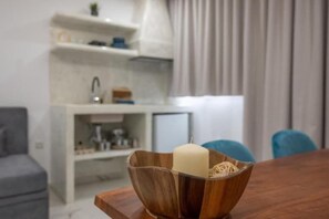 Un cuenco de madera con una vela y fideos sobre una mesa.