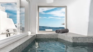 Une petite piscine privée avec vue sur la mer, une baignoire blanche et une serviette.
