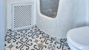 Une salle de bain avec un lavabo blanc, un miroir et des toilettes.