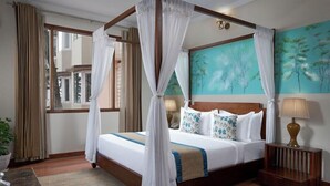 A four-poster bed with white linens and blue accents, a wooden headboard, and a painting of trees on the wall. - 8fold By Larisa Shimla (Shimla)