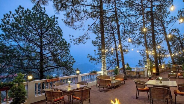 An outdoor patio with wicker furniture, string lights, and a fire pit. - 8fold By Larisa Shimla (Shimla)