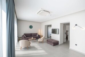 A modern living room with a sofa, armchairs, and a coffee table. - Pefkaki Boutique Hotel (Loutraki-Agioi Theodoroi)