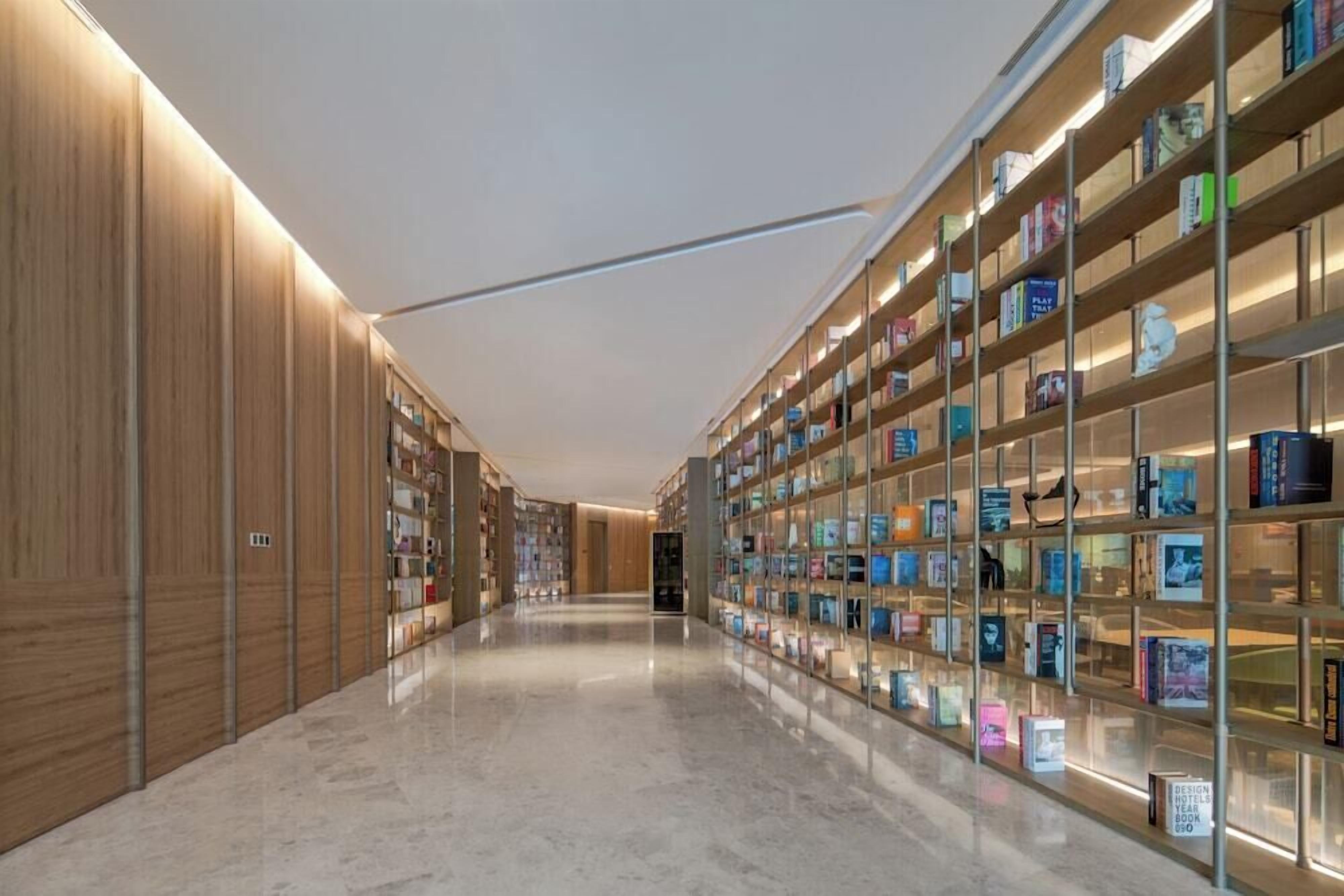 A modern library interior with marble floors and wooden bookshelves.
