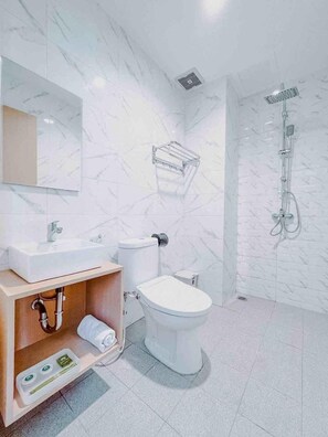 Une salle de bain moderne avec un pare-feu en marbre, un meuble-lavabo en bois, des toilettes, une douche et un miroir.