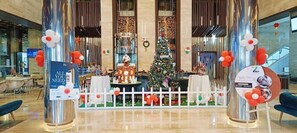A lobby with a Christmas tree, white picket fence, and a sign that reads "ALL YOU NEED IS THE". - Fortune Park Vellore (Katpadi)