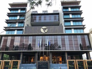 A modern hotel with a prominent logo, multiple balconies, and a sign indicating it is a member of the InterContinental Hotels Group. - Fortune Park Vellore (Katpadi)
