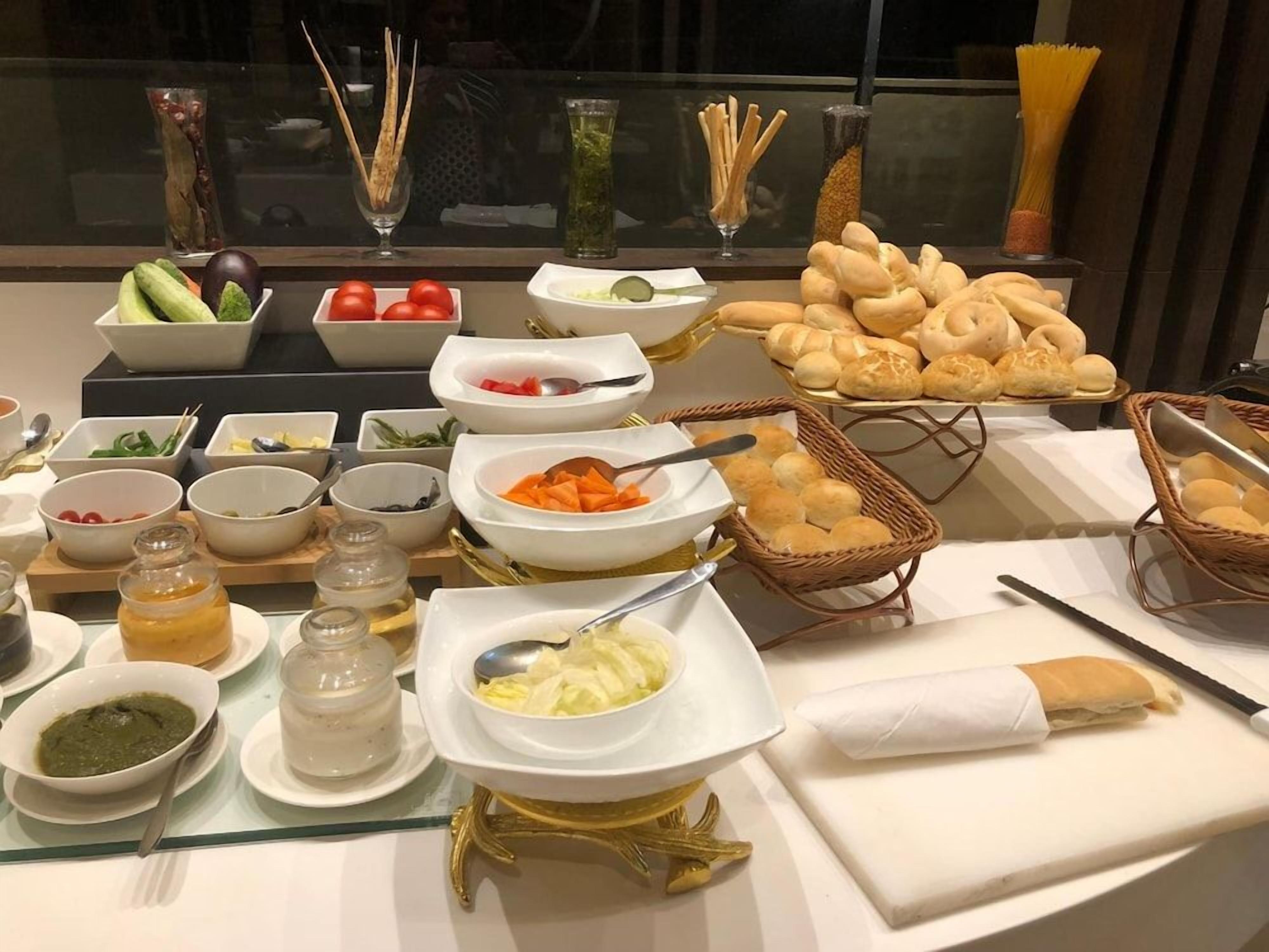 A buffet table with various food items and condiments.