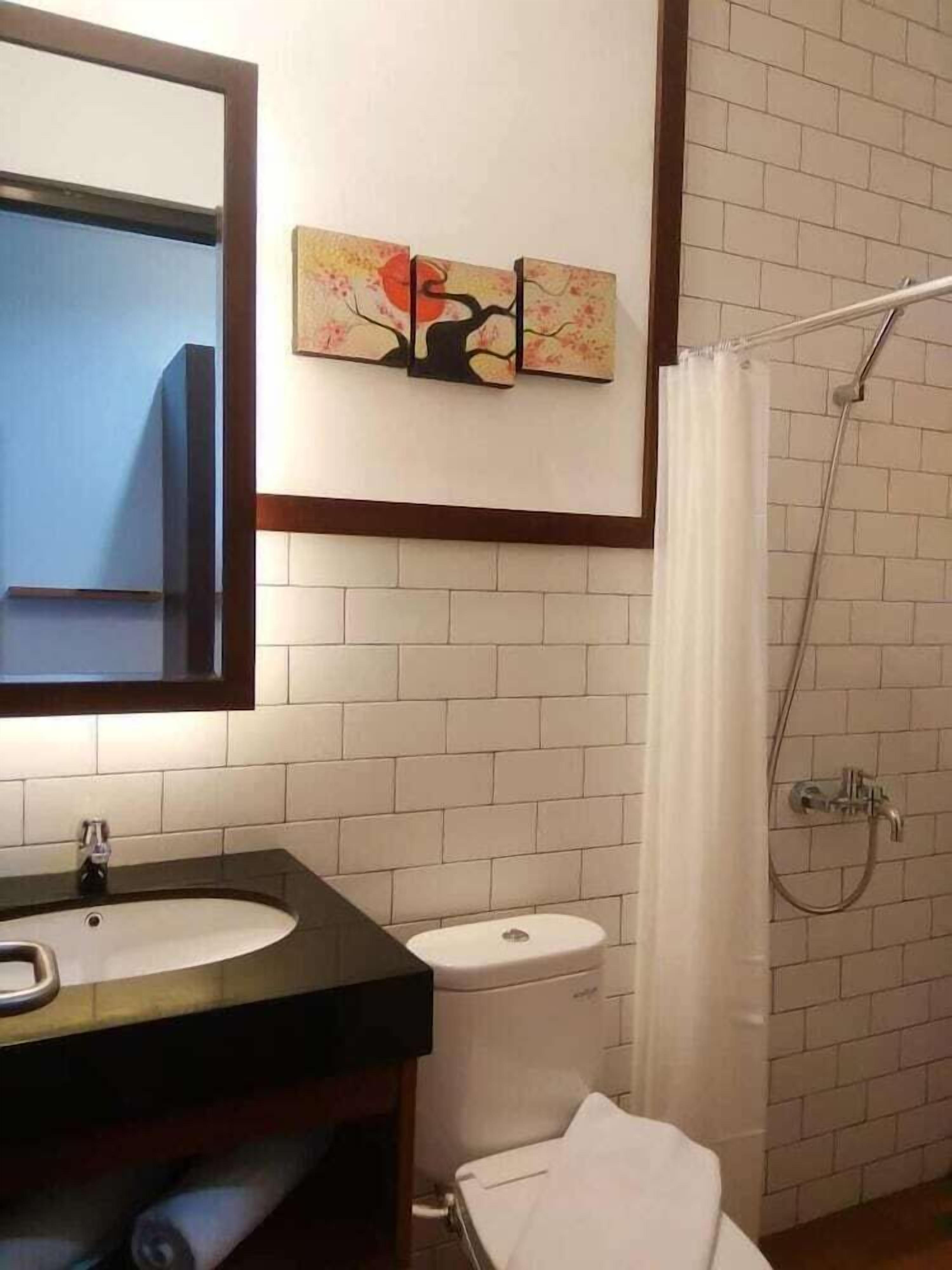 Une salle de bain avec un lavabo, des toilettes et une douche.