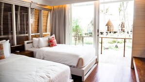 Ein Hotelzimmer mit zwei Betten, einem Balkon und Blick auf den Außenbereich.