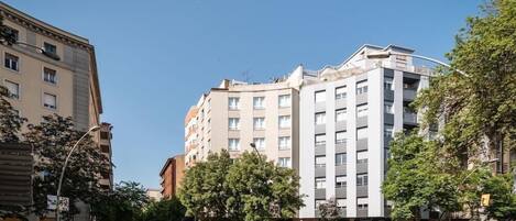 Un edificio de varios pisos con diseño moderno, que combina espacios residenciales y comerciales.