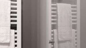 Une salle de bain avec un porte-serviettes et une serviette qui y est accrochée.