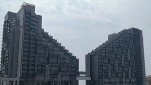 Un edificio moderno con un diseño arquitectónico único, que presenta un patio central con piscina.