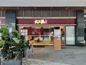 A restaurant with a modern facade, featuring a prominent neon sign and a traditional Japanese design. - R&F Princess Cove CIQ Premium Sea View Suites by NEO (Johor Bahru)