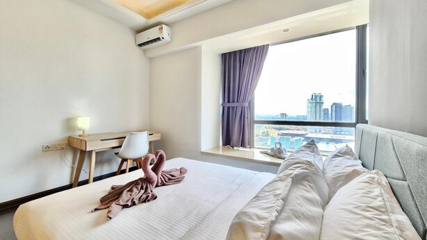 Ein Hotelzimmer mit Bett, Schreibtisch, Stuhl, Klimaanlage und einem Fenster mit Blick auf die Stadt.