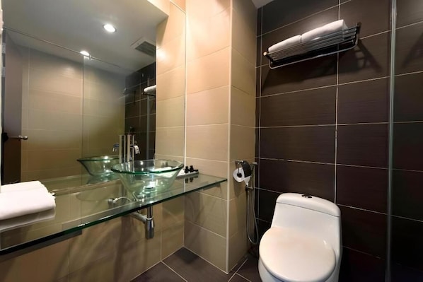 A modern bathroom with a glass sink, white toilet, and a towel rack. - Kingwood Hotel Mukah (Borneo (MY))