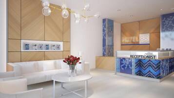 A hotel reception area with a reception desk, a sofa, a coffee table, and a chandelier.