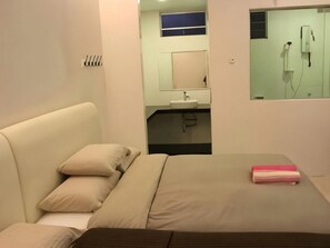A hotel room with a bed, a bedside table, a mirror, and a bathroom visible through an open door. - David's Hotel Apartment @ Greenhill Resort (Tanah Rata)