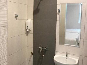 A bathroom with a shower, toilet, and sink. - Brezza Hotel Sitiawan (Lumut)