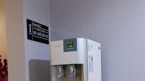 A water dispenser in a hotel corridor with a sign indicating room numbers 101-104. - Brezza Hotel Sitiawan (Lumut)