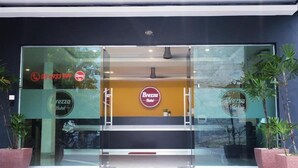 A modern hotel entrance with a glass facade, a visible phone number, and a sign for 'Brezza Hotel'. - Brezza Hotel Sitiawan (Lumut)