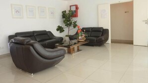 A modern waiting area with two leather sofas, a coffee table, and framed artwork on the wall. - Brezza Hotel Sitiawan (Lumut)