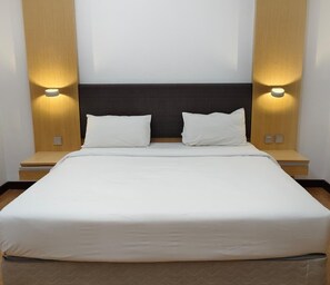 A hotel room with a large bed, two bedside tables, and wall-mounted lighting. - Imperial Suites Miri @ Diamond Tower (Miri)