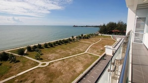 A balcony with a view of a landscaped area and a body of water. - Imperial Suites Miri @ Diamond Tower (Miri)