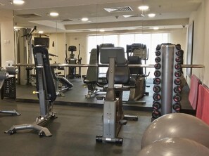 A gym with exercise equipment, mirrors, and a large window. - Raintree Resort Suite At Sunway Pyramid Tower (Petaling Jaya)