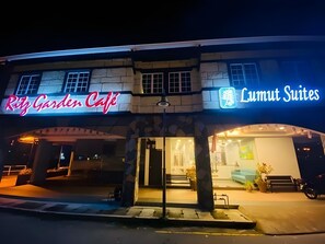 En byggnad med skyltar som visar ”Ritz Garden Café” och ”Lumut Suites”.