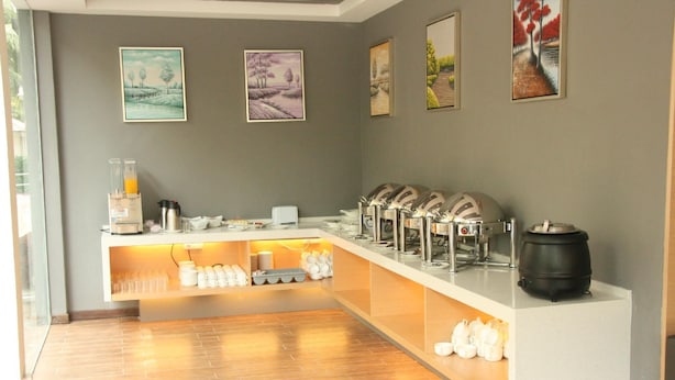 A breakfast bar with various food and drink options, including a coffee machine and a kettle. - Lumut Suites (Lumut)