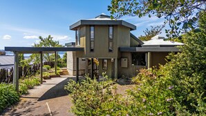 A modern two-story building with a flat roof and large windows. - Aquarius home with vintage aesthetic and Lakeview (Rotorua)