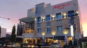 A multi-story hotel with a modern design, featuring a prominent sign for 'Mega Paradise Hotel.'