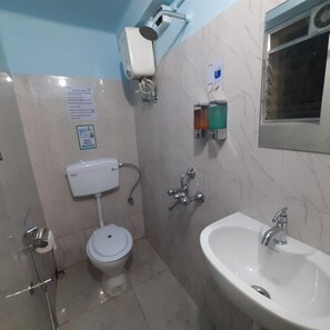 A bathroom with a toilet, bidet, sink, and a showerhead. - Bubble Beds Hostel (Kolkata)