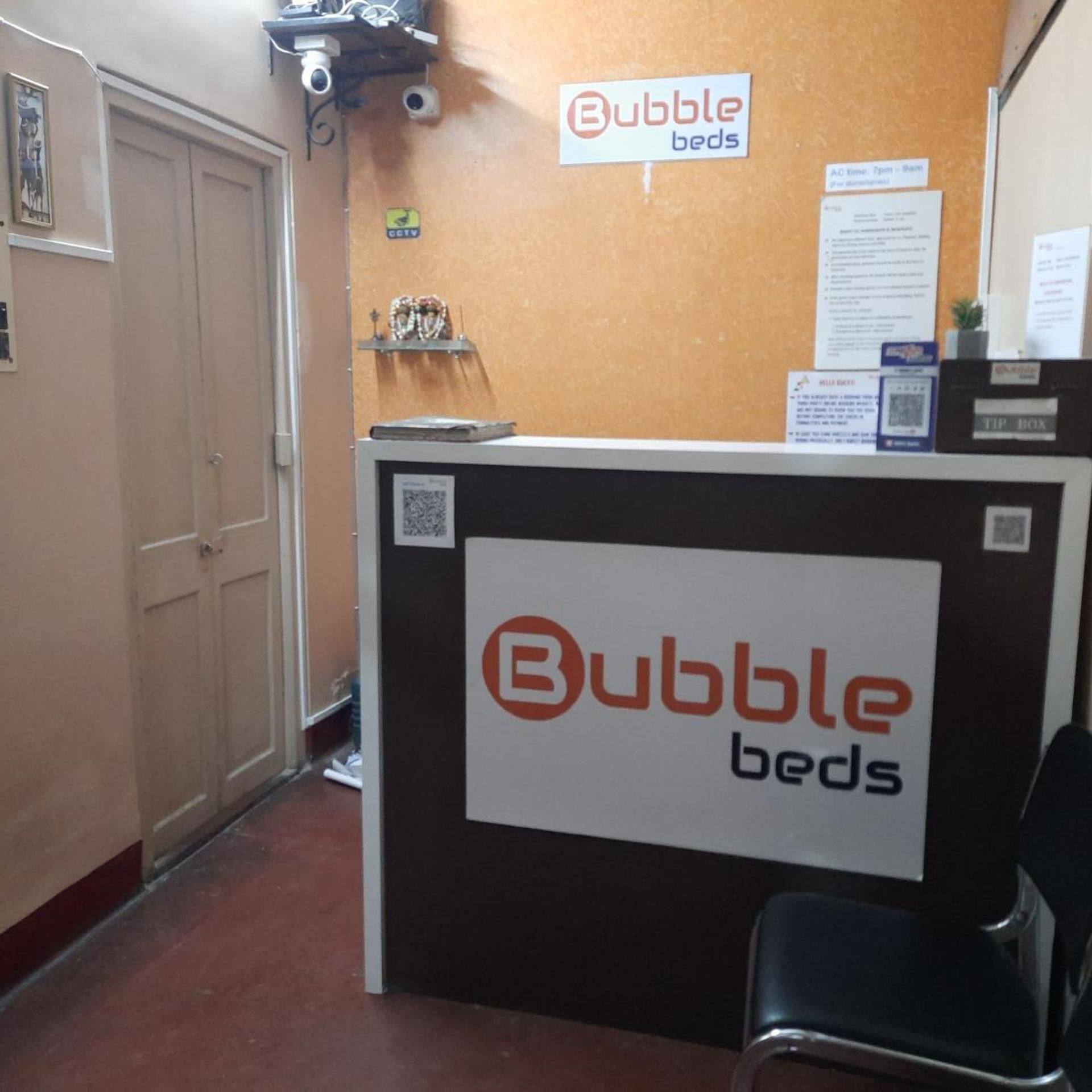 A reception desk with a sign for 'Bubble beds' and a CCTV camera above it.