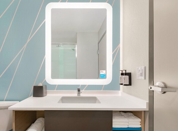A bathroom with a white sink, a mirror, and a towel rack. - Avid Hotels Fort Mill - Amusement Park (Fort Mill)