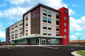 Een modern hotelgebouw met een opvallend ‘avid’ logo, grote ramen en een plat dak.